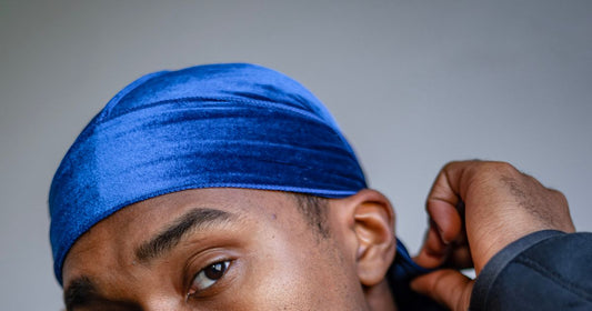 Tying a blue durag over the hair, hands at the back of the head
